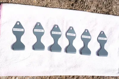 Seis espátulas Meduclean de color gris, etiquetadas con el número del voluntario que participó en las pruebas.