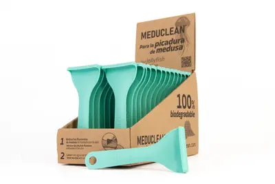 Caja con set de espátulas Meduclean de color azul marino, en ángulo girado, con una espátula de muestra apoyada horizontalmente sobre la caja.
